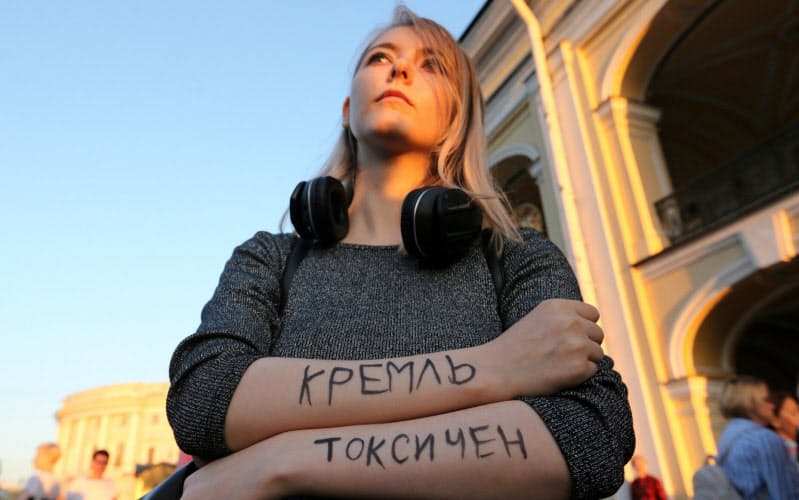 「クレムリン（ロシア大統領府）は有毒だ」と腕に書いて、ナワリヌイ氏の毒殺未遂疑惑に抗議するロシア市民（８月20日、サンクトペテルブルク）＝ロイター
