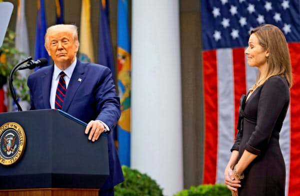 米連邦最高裁判事候補に指名されたバレット氏(右)とトランプ米大統領(26日、ホワイトハウス)=ロイター
