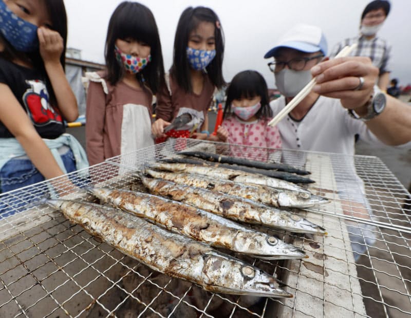 ゆりあげ港朝市の「さんま祭り」で焼かれるサンマ(27日午前、宮城県名取市閖上地区)=共同 ゆりあげ港朝市の「さんま祭り」で焼かれるサンマ(27日午前、宮城県名取市閖上地区)=共同