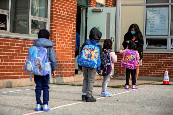 15日、カナダ・オンタリオ州で新型コロナウイルスの流行以来初めて小学校に登校する児童たち=ロイター