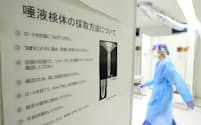 唾液の抗原検査の検体採取方法について説明する張り紙（24日、成田空港）