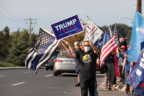 4日、トランプ米大統領が入院する病院の周辺に集まった支持者ら=ロイター