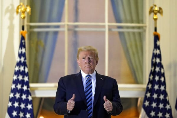 ホワイトハウスに戻り、ポーズをとるトランプ米大統領(5日)=AP