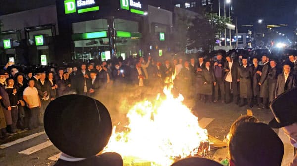 6日、厳しい規制の対象となったNY市ブルックリンのバラパーク地区では超正統派ユダヤ教徒らが通りに火を放ち抗議した=AP