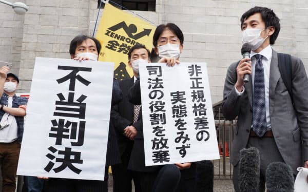 最高裁前で「不当判決」の紙を掲げる原告側の弁護団(13日)