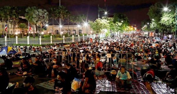 15日、路上に座り込むデモ隊(バンコク)=ロイター