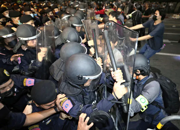 警官隊と衝突する反体制デモの参加者(15日、バンコク)=AP