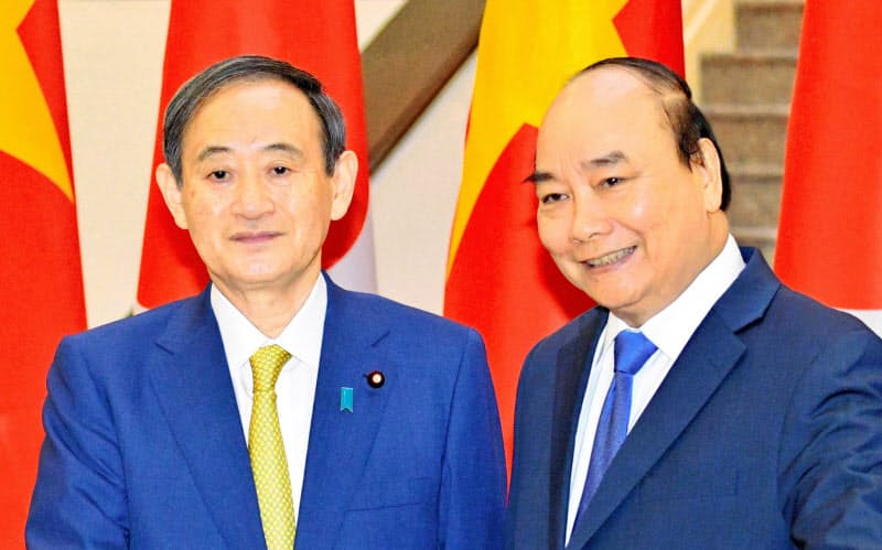 会談前に握手するベトナムのフック首相(右)と菅首相(19日、ハノイ)=代表撮影・共同 会談前に握手するベトナムのフック首相(右)と菅首相(19日、ハノイ)=代表撮影・共同