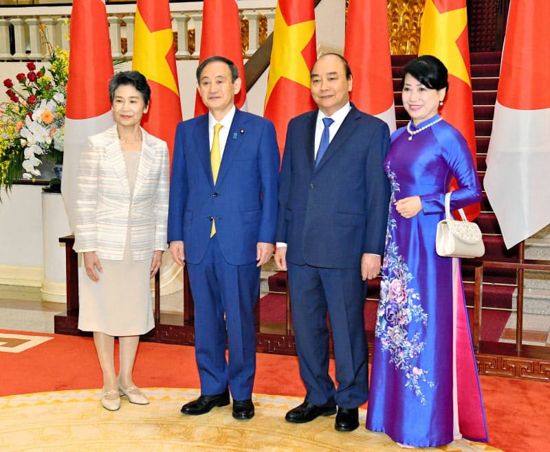 ベトナムのフック首相(中央右)とともに記念撮影に応じる菅首相(同左)と真理子夫人(19日、ハノイ)=代表撮影・共同 ベトナムのフック首相(中央右)とともに記念撮影に応じる菅首相(同左)と真理子夫人(19日、ハノイ)=代表撮影・共同