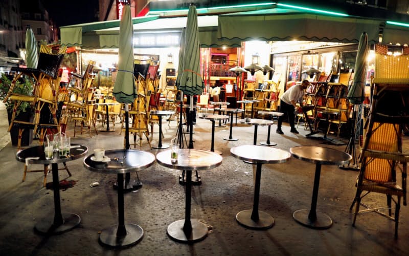 夜間外出禁止の時間前に店を閉める店員(17日、パリ)=ロイター 夜間外出禁止の時間前に店を閉める店員(17日、パリ)=ロイター