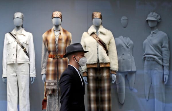 20日、チェコの首都プラハでマスクをして歩く人=ロイター