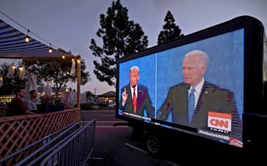 カリフォルニア州のバーでモニターに映る討論会を見る人たち=ロイター