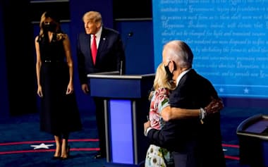 討論会を終え、夫人と抱き合うバイデン氏(手前)。奥はトランプ氏夫妻=ロイター