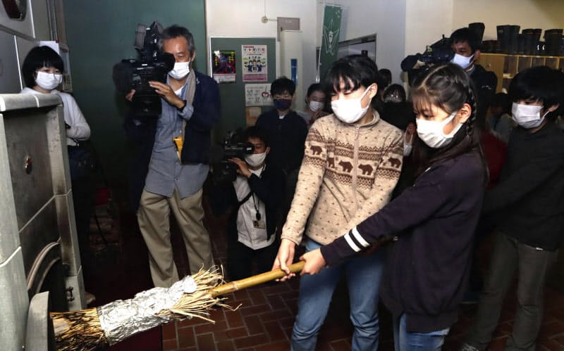 神戸市立六甲山小で開かれたまきストーブの「火入れ式」(23日午前)=共同 神戸市立六甲山小で開かれたまきストーブの「火入れ式」(23日午前)=共同