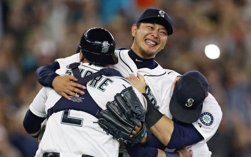 2015年8月のオリオールズ戦で無安打無得点試合を達成し、チームメートと抱き合って喜ぶマリナーズの岩隈(中央)=USA TODAY 2015年8月のオリオールズ戦で無安打無得点試合を達成し、チームメートと抱き合って喜ぶマリナーズの岩隈(中央)=USA TODAY
