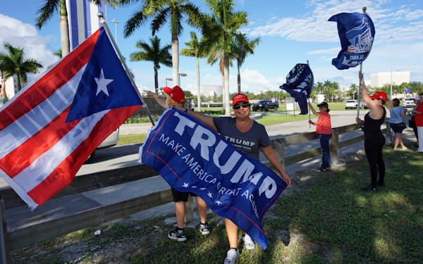 キューバの慰霊塔の前に集まるトランプ支持者たち（18日、米フロリダ州マイアミ・デード郡）