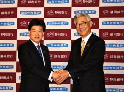 包括業務提携について発表した静岡銀行の柴田久頭取(左)と山梨中央銀行の関光良頭取(28日、東京・千代田のパレスホテル東京)
