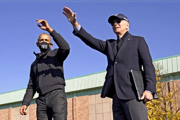 10月31日、オバマ前大統領(左)はバイデン前副大統領について「良識のある大統領になる」と語った(中西部ミシガン州)=AP