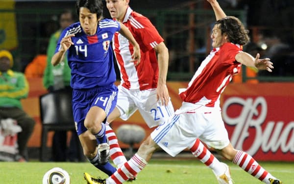 2010年6月、サッカーW杯南アフリカ大会のパラグアイ戦で攻め込む中村憲剛（左）=共同