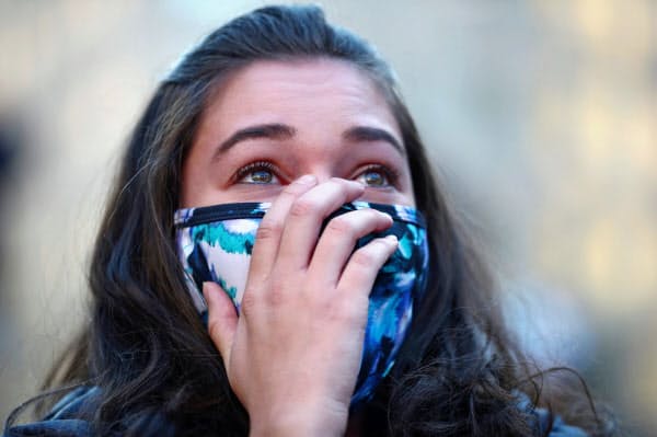 ミシガン州でバイデン氏が勝利確実とのニュースに見入る女性(4日、首都ワシントン)