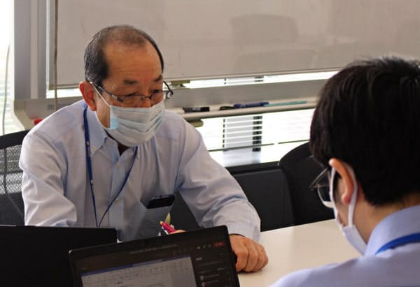アジア拠点と結んだテレビ会議で話し合う希代博文さん(10月14日、東京都品川区の明電舎本社)