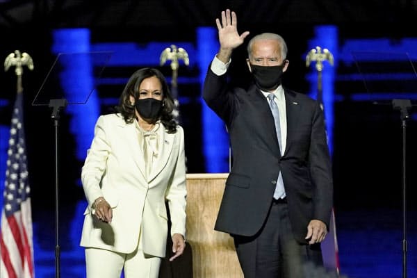 ステージから支持者に手を振るバイデン氏(右)とハリス氏(7日、デラウェア州ウィルミントン)=AP