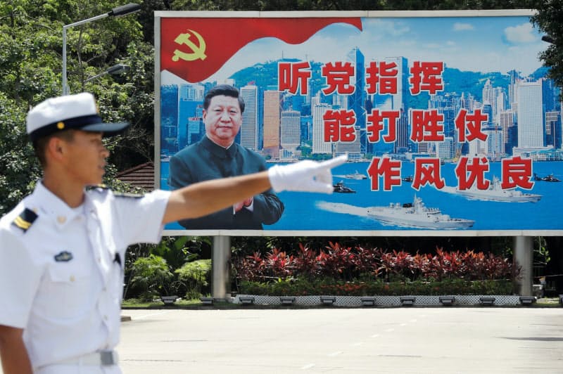 習国家主席の看板の前に立つ中国人民解放軍の兵士(2019年6月30日、香港) 習国家主席の看板の前に立つ中国人民解放軍の兵士(2019年6月30日、香港)