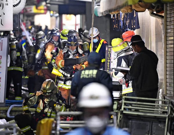 大阪市北区の建物火災で消火活動に当たる消防隊員ら(17日午後11時45分)=共同