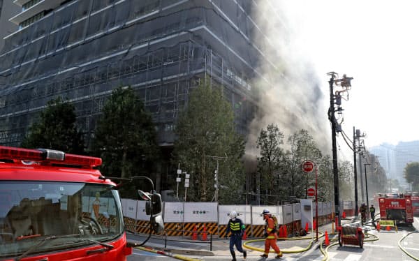 白煙が上がり消火活動の続く虎ノ門ヒルズレジデンシャルタワーの工事現場(18日午後、東京都港区)