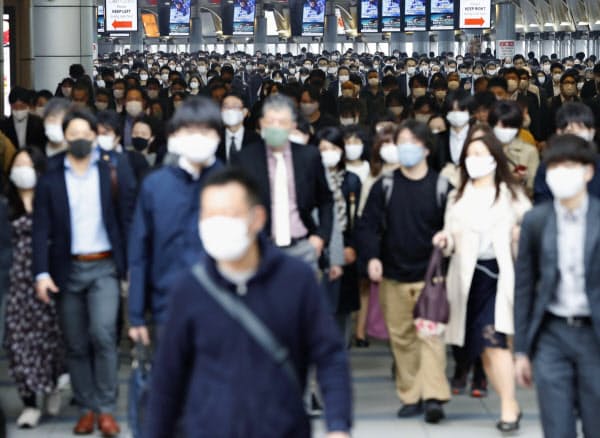 マスクを着けて通勤する人たち(19日、東京・JR品川駅)=共同