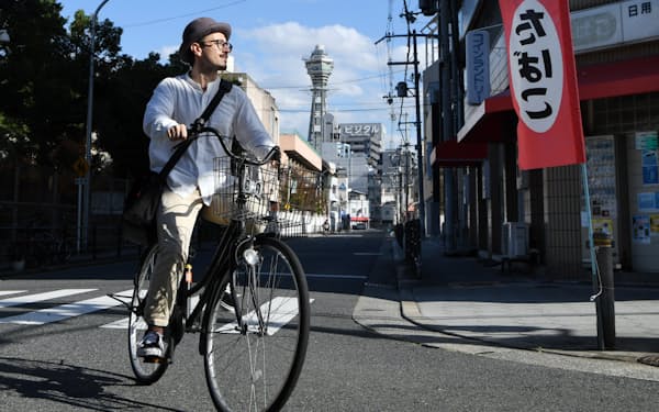 自転車に乗って通勤するイタリア人のヤコポ・ロサミリアさん（19日、大阪市浪速区）