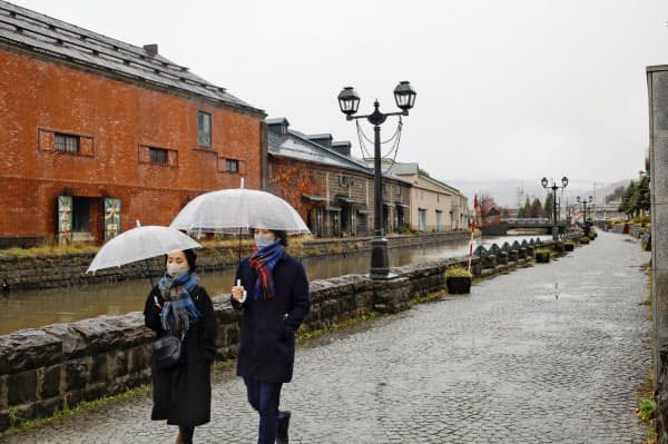 北海道小樽市の観光名所「小樽運河」を歩く人=21日午前