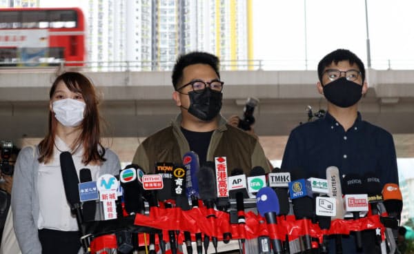 裁判の前に取材に応じる周庭氏(左)ら(23日、香港)