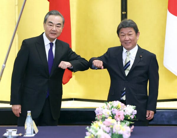 中国の王毅国務委員兼外相(左)と会談に臨む茂木外相(24日、東京都港区の飯倉公館)=代表撮影