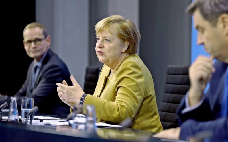 コロナ規制の延長を決めて記者会見するドイツのメルケル首相(中)=ロイター コロナ規制の延長を決めて記者会見するドイツのメルケル首相(中)=ロイター
