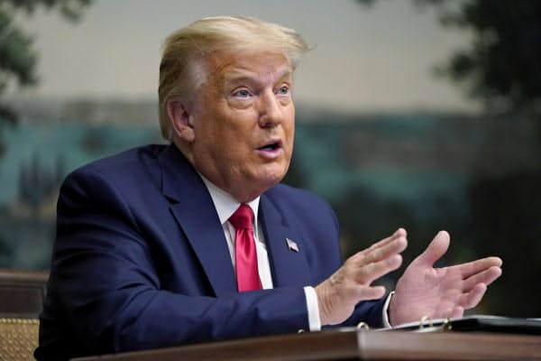 26日、ホワイトハウスで記者団の質問に答えるトランプ氏=AP