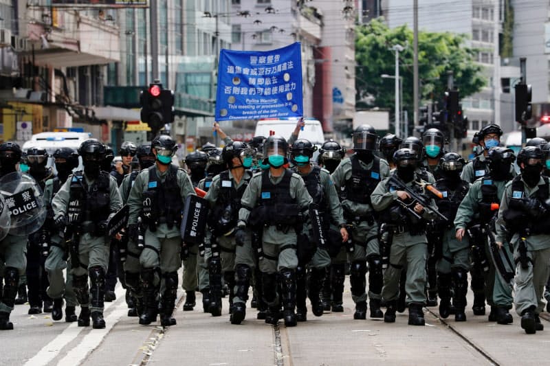 抗議活動を取り締まる香港警察(7月1日、香港)=ロイター 抗議活動を取り締まる香港警察(7月1日、香港)=ロイター
