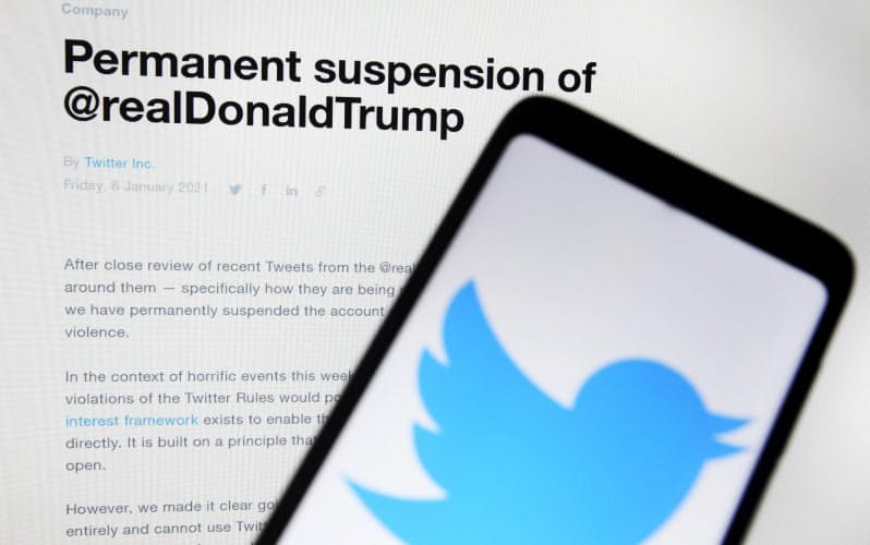 トランプ米大統領のアカウントの永久凍結を発表したツイッター社のウェブサイトと同社ロゴ=ゲッティ共同 トランプ米大統領のアカウントの永久凍結を発表したツイッター社のウェブサイトと同社ロゴ=ゲッティ共同