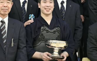 優勝杯を手に笑顔で記念撮影に応じる竹ノ内佑也（3日、日本武道館）=共同