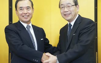 握手を交わす横浜銀の寺沢頭取(左)と東日本銀の石井頭取（14日、東京・大手町）