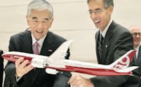 記者会見で「777X」の模型を手にする東レの日覚昭広社長(左)とボーイングのジョン・トレーシーCTO（17日午後、東京都中央区）