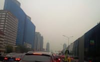 APEC閉幕4日目にして、北京の空は再び大気汚染で白くよどみ、交通渋滞も復活した（11月15日、北京市内の長安街）