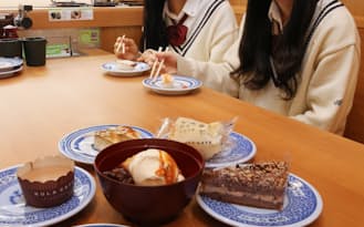すしとデザートを食べる女子高生（東京都豊島区のくら寿司）