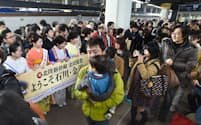 JR金沢駅に到着し和服姿の女性の歓迎を受ける北陸新幹線の乗客ら（14日）