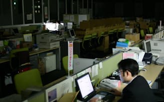 日本では働く時間が長い人が評価される企業風土があるとの指摘も（一斉消灯したオフィスで働くサラリーマン）