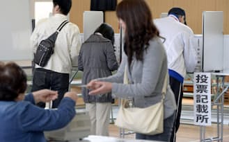 大阪市内の投票所で投票する有権者=12日午前