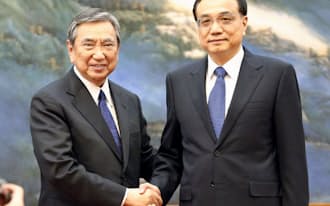 北京の人民大会堂で中国の李克強首相（右）と握手する河野洋平元衆院議長（14日）=共同
