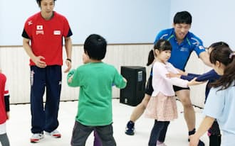 子どもたちを指導する五輪金メダリストの米田さん(左)と米満さん