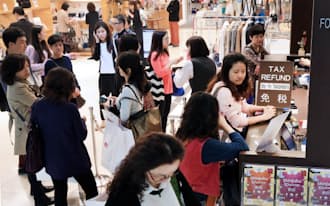 百貨店の免税カウンターに並ぶ訪日外国人（東京都渋谷区の高島屋新宿店）