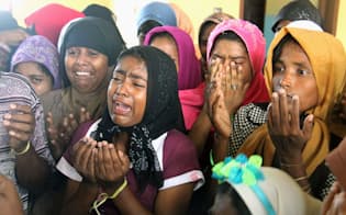 インドネシア・アチェ州の仮設キャンプで、涙を流しながら神に祈りをささげるロヒンギャの女性たち（5月14日、共同）